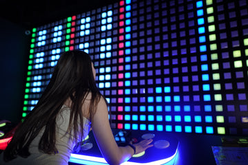 Person playing interactive control game with LED light wall at Power Play Sydney venue